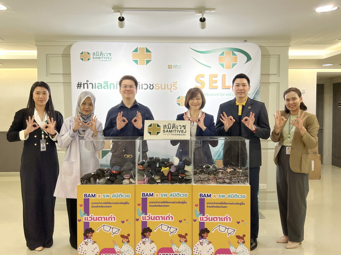 A group of people standing in front of a display

Description automatically generated